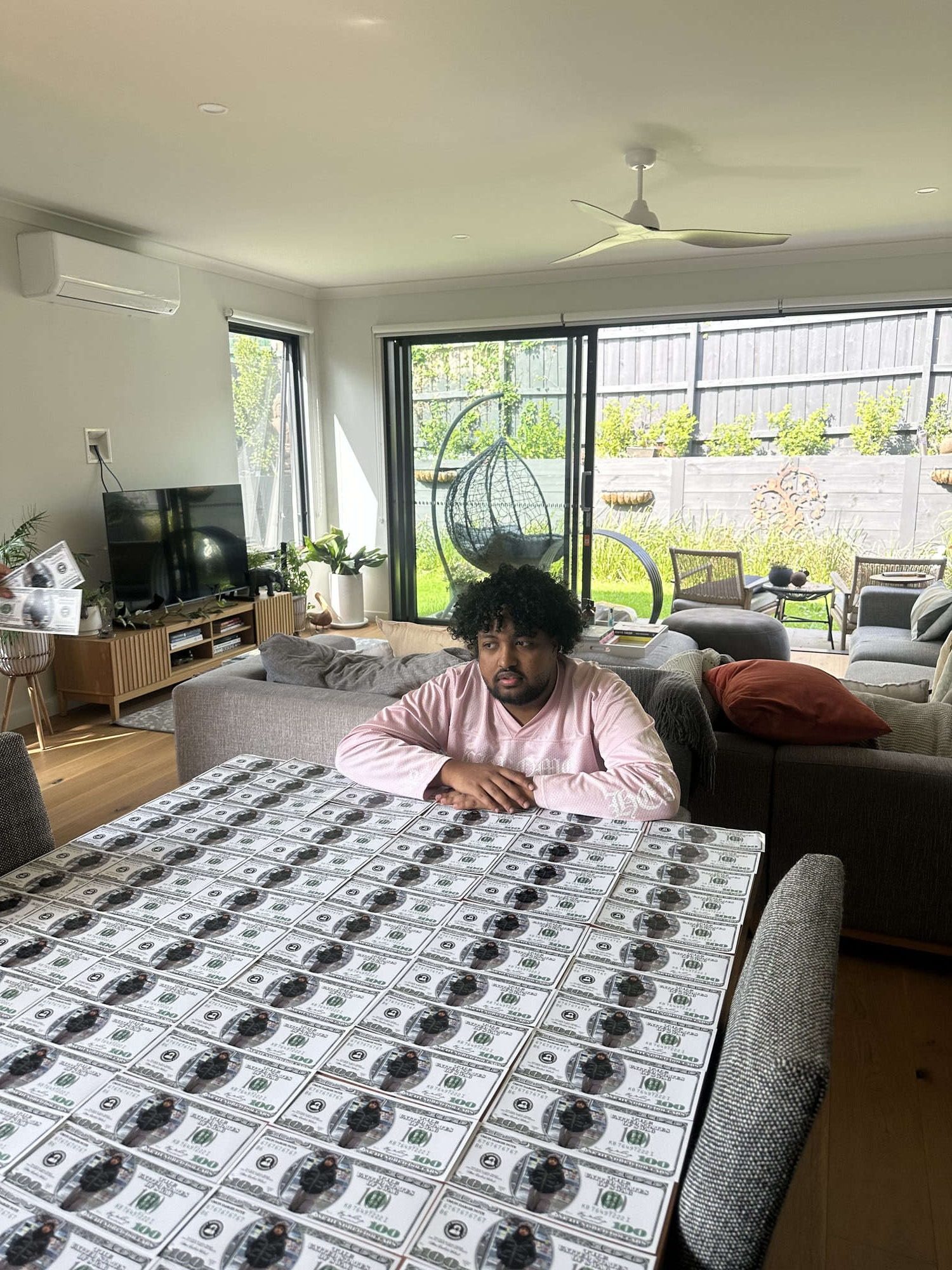 An entire dining table covered edge to edge with uncut printed sheets of Mahdi Bucks notes